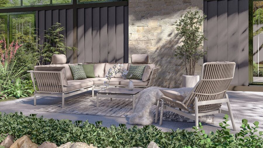 Terrasse extérieure avec canapé d'angle gris clair, fauteuil et table basse ; cadre naturel avec plantes.