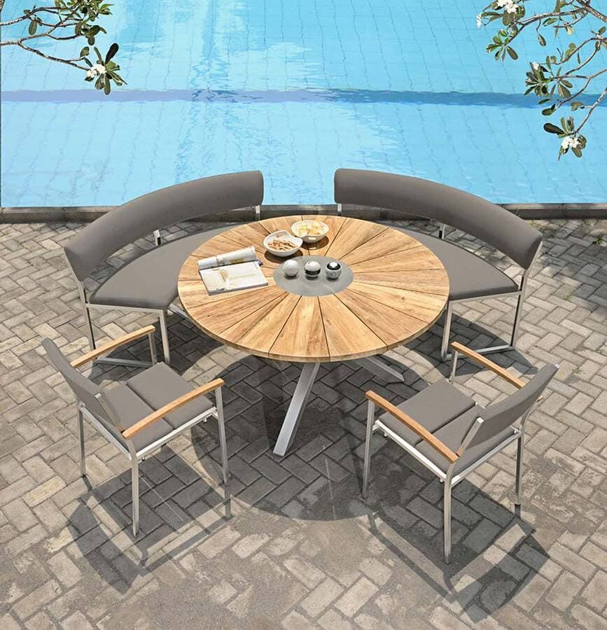 Ensemble repas d'extérieur : table ronde en bois, bancs incurvés, chaises près de la piscine.