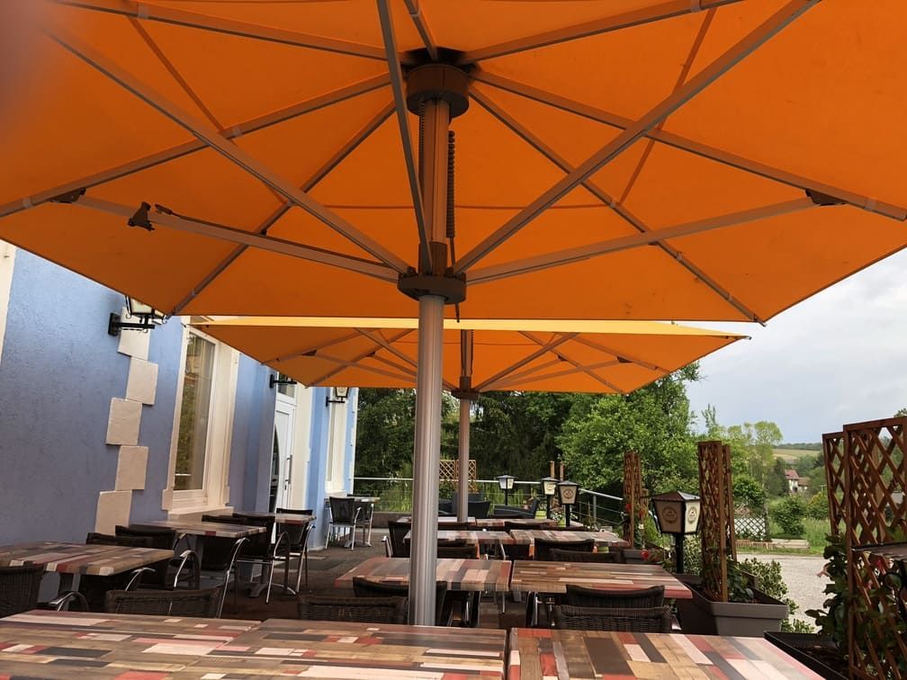 Terrasse de restaurant sous des parasols orange.