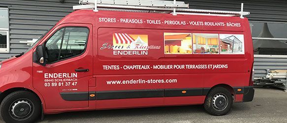 Fourgonnette rouge avec logo et coordonnées de l'entreprise. Échelle sur le toit. Stationnée à l'extérieur.
