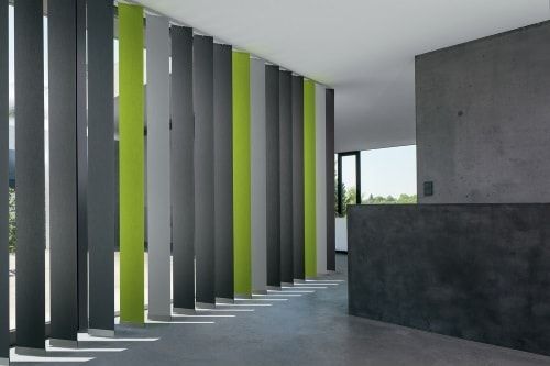 Des stores verticaux dans les tons de gris et de vert citron délimitent un espace intérieur moderne.