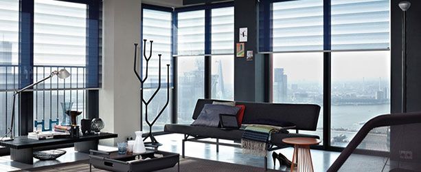 Salon moderne avec baies vitrées, canapé et vue sur la ville.