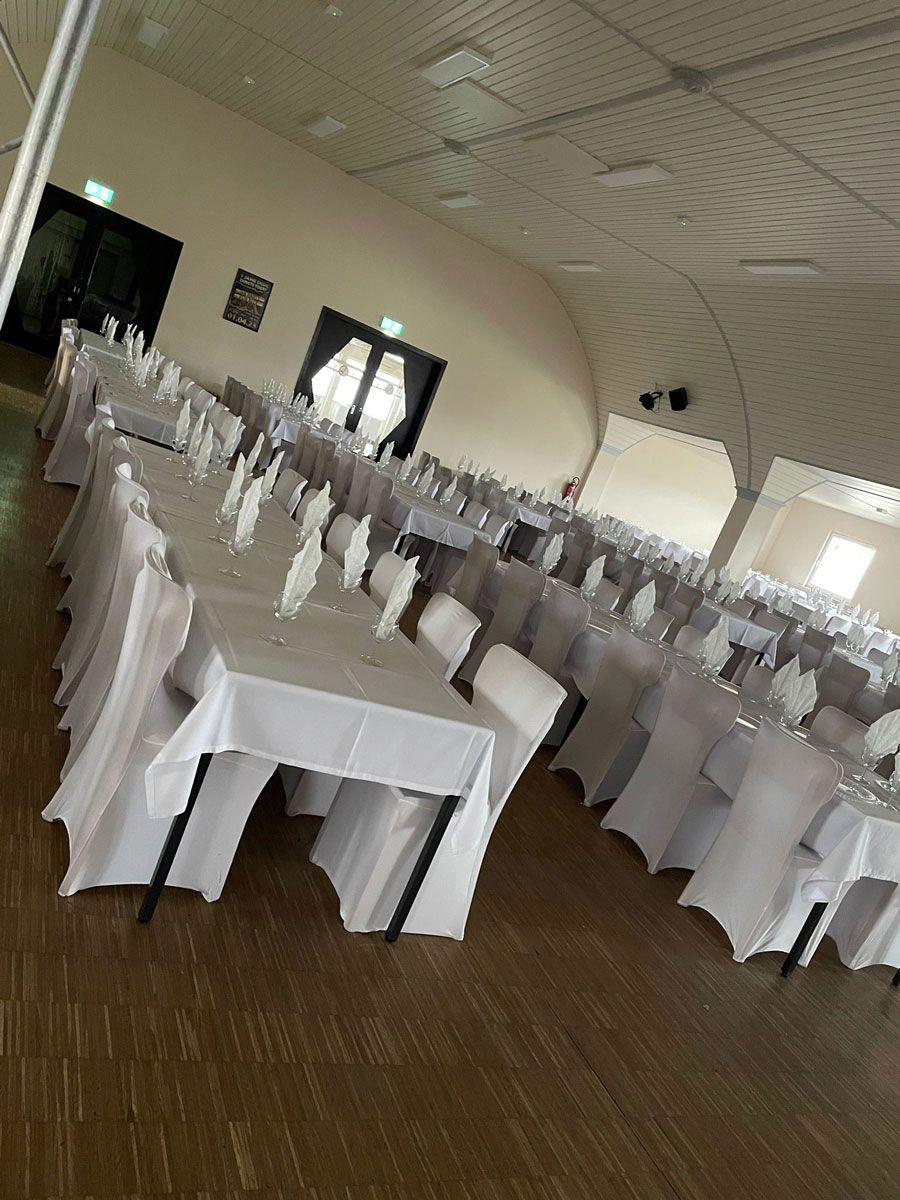 Ein großer Raum mit Tischen und Stühlen für eine Party.