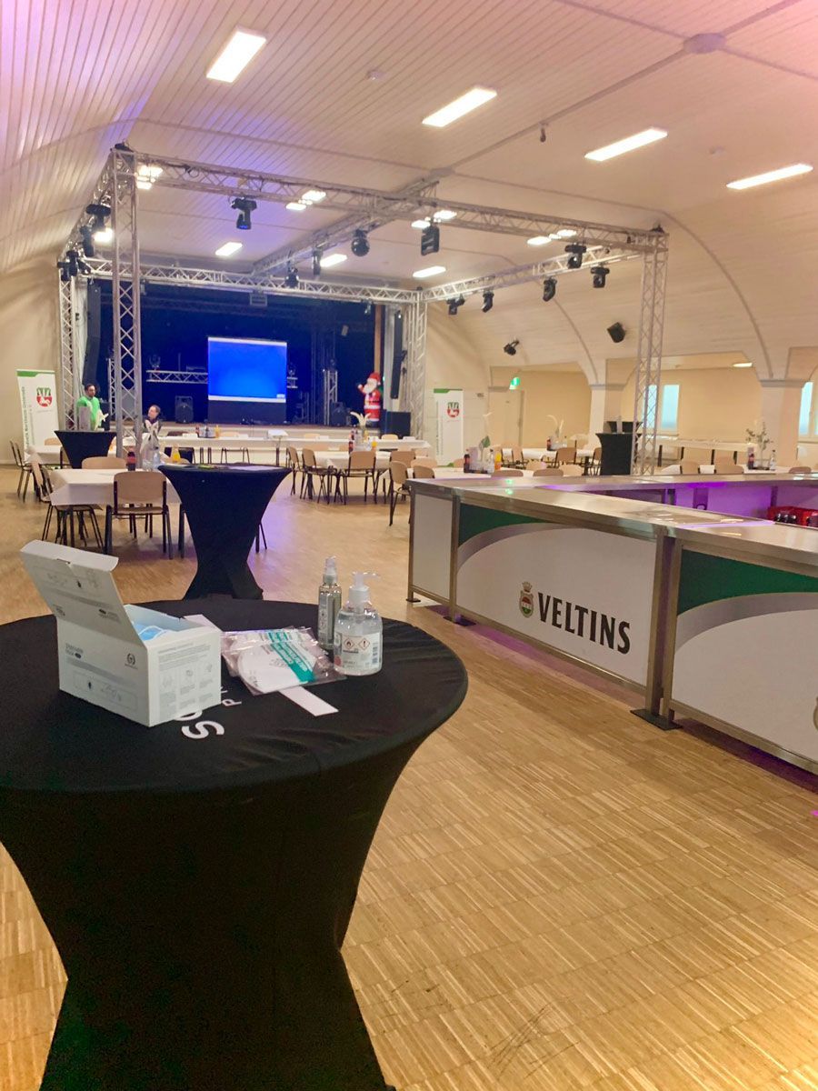 Eine große Menschenmenge tanzt in einem Club mit violetten Lichtern.