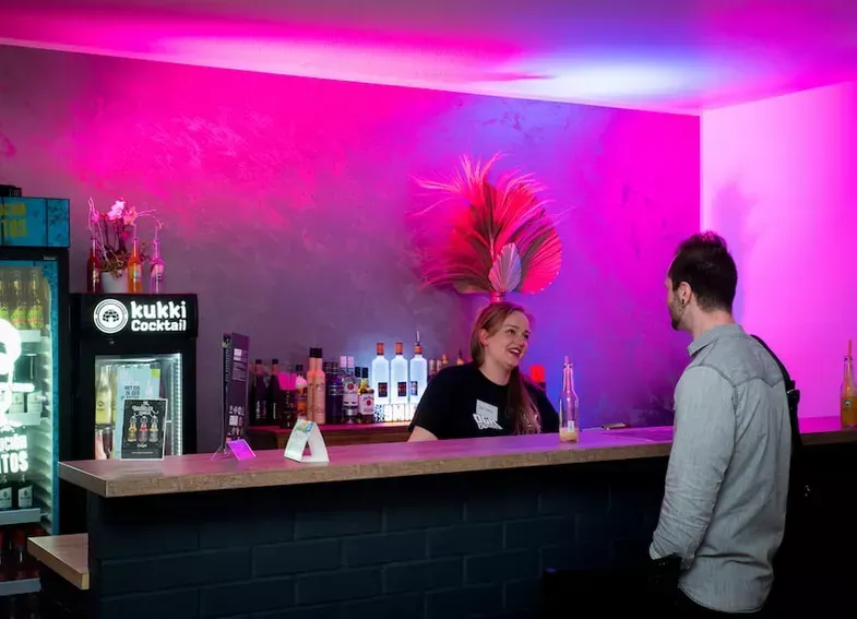 Ein Mann und eine Frau stehen in einer Bar und unterhalten sich.