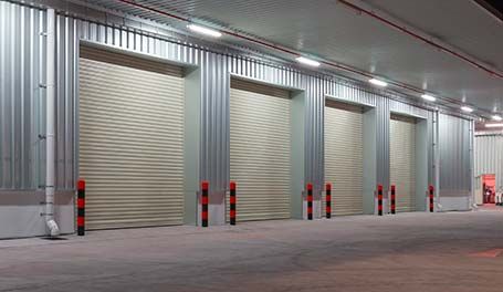 Una fila de puertas de garaje en un almacén por la noche.