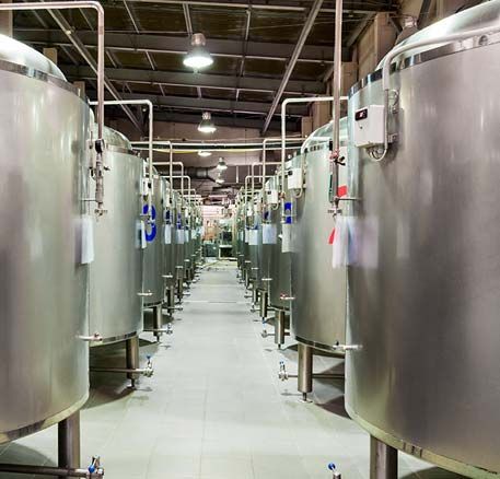 Un almacén lleno de muchos tanques de acero inoxidable.