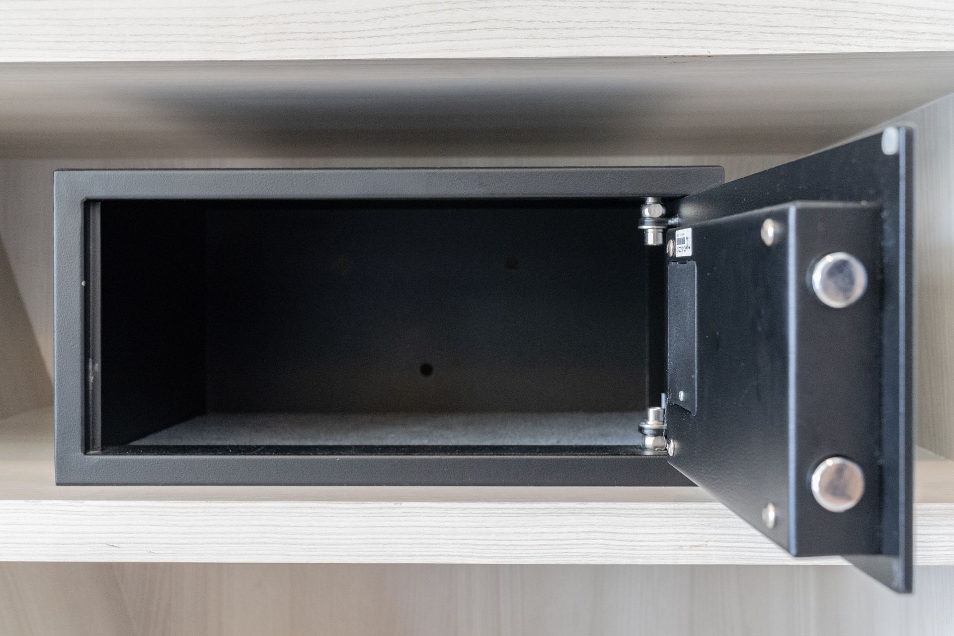 Tiroir d'armoire en métal noir ouvert, porte grande ouverte, révélant un intérieur vide.