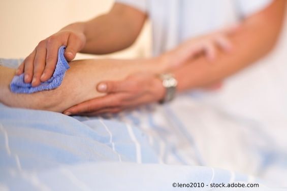 Pflegerin wischt Schweiß vom Arm