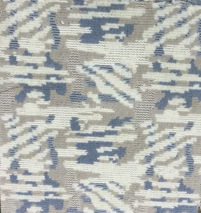 Muestra de tela con un estampado de camuflaje abstracto y pixelado en tonos azules, gris claro y blanco.