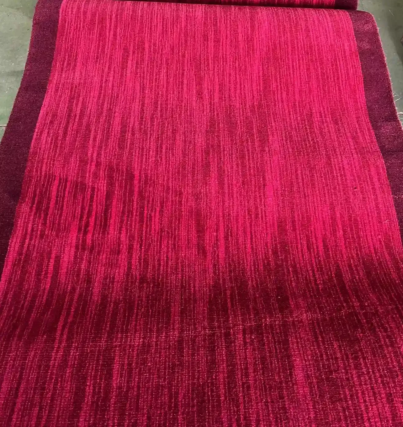 Una alfombra roja con intrincados estampados florales en negro, verde y azul