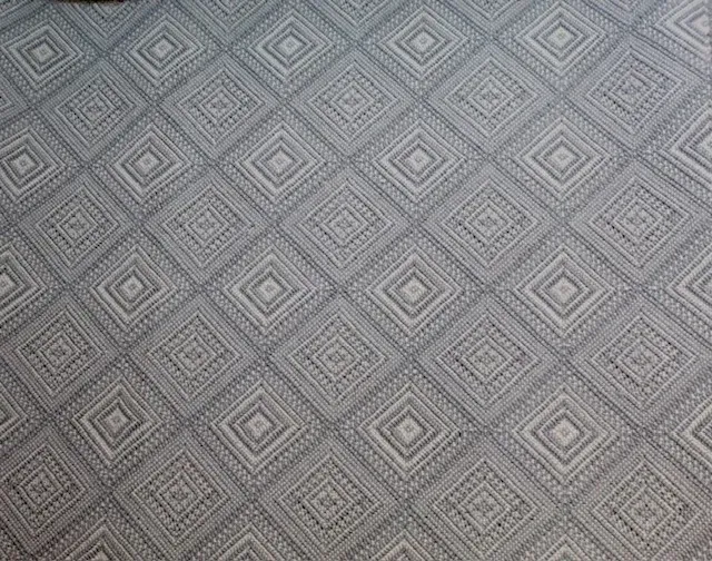 Un estampado de rayas verticales repetitivas en tonos marrones, rojos, crema, grises y negros