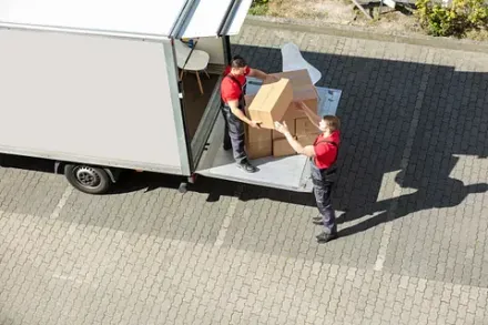 Dos hombres están cargando cajas en un camión de mudanzas.