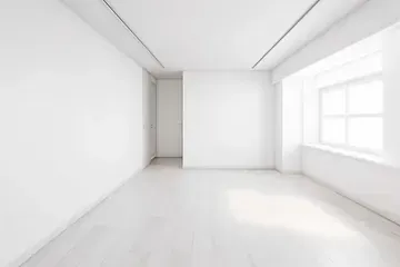 Una habitación vacía con paredes blancas y una ventana.