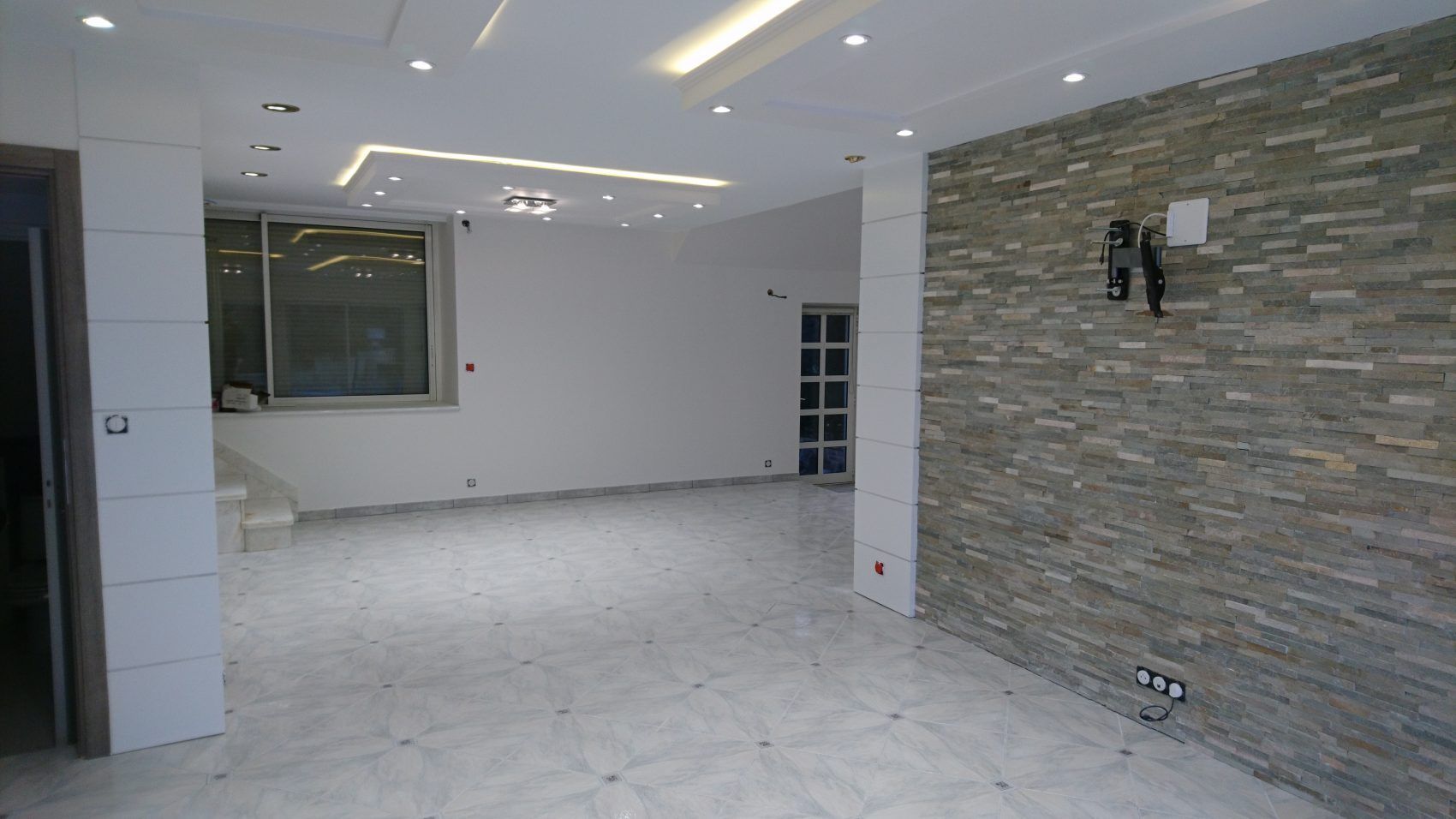 Une pièce rénovée avec murs peints en blanc et carrelage au sol