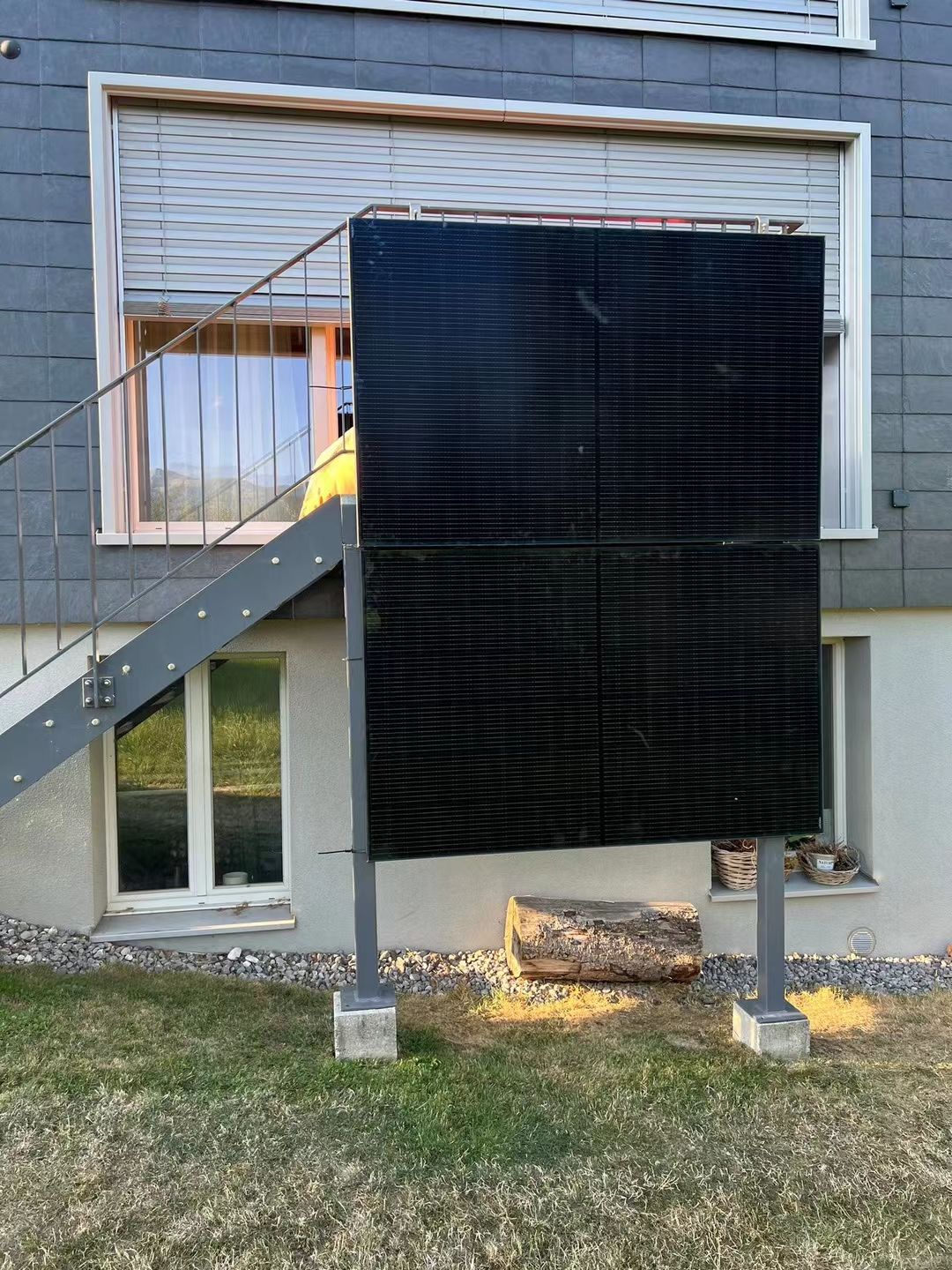 ein großes schwarzes Solarpanel steht vor einem Gebäude