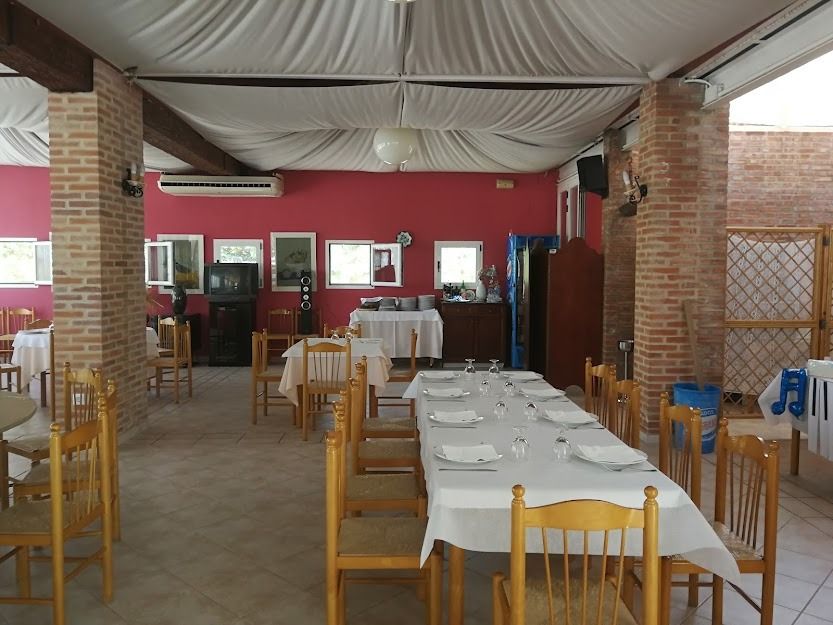 Un restaurante con mesas y sillas y una pared roja.