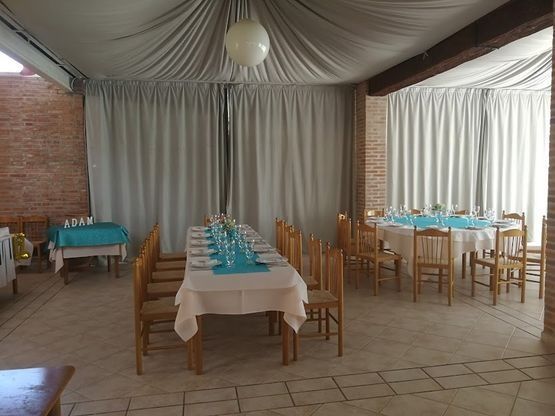 Una gran sala con mesas y sillas preparadas para una fiesta.