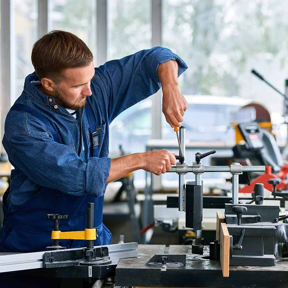 Ein Mann arbeitet in einer Fabrik an einer Maschine.