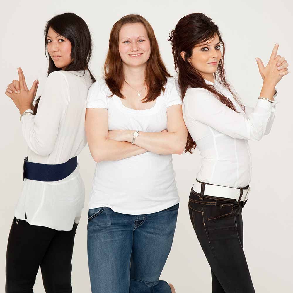 Drei Frauen stehen mit verschränkten Armen nebeneinander