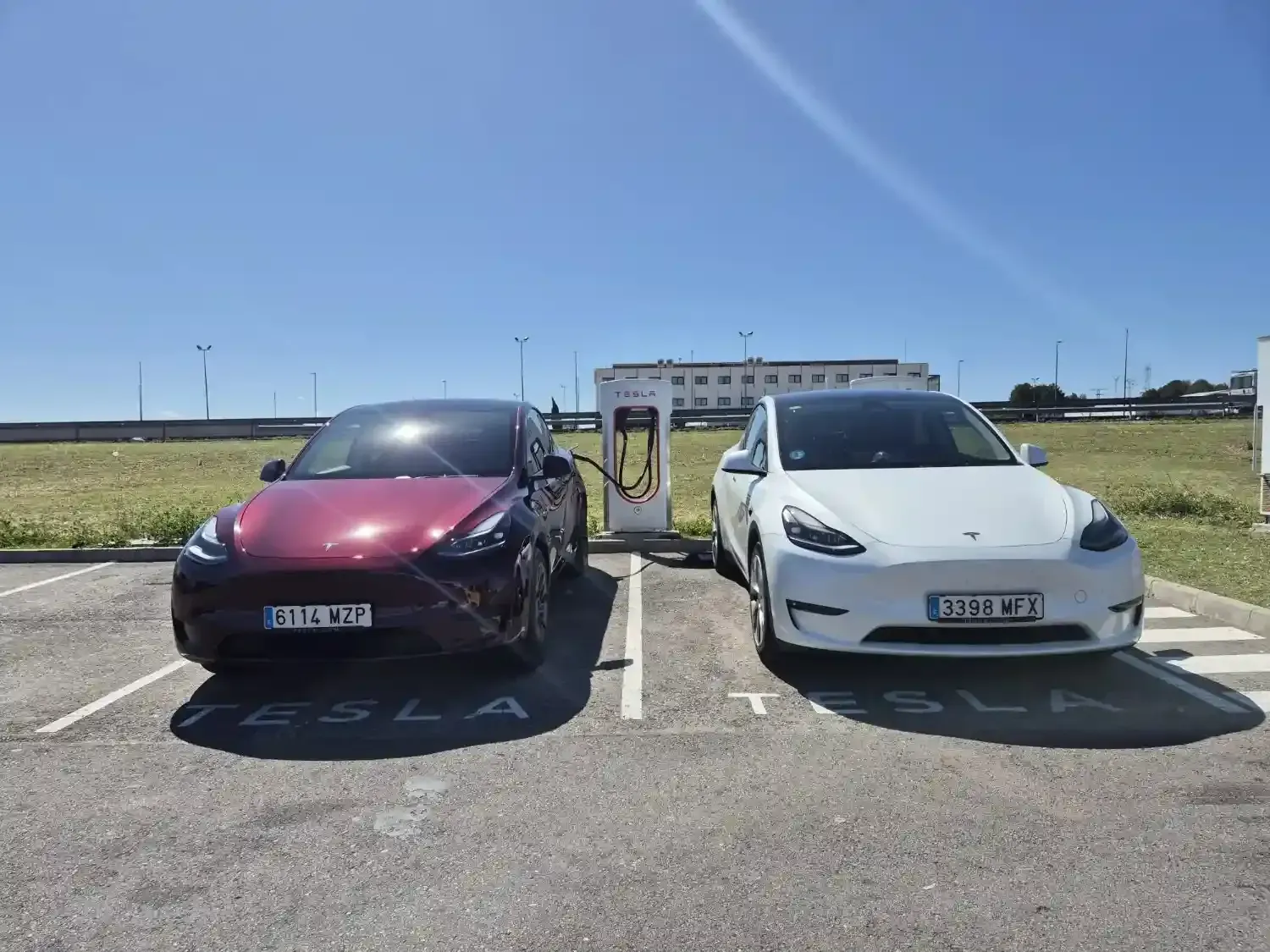 Una persona con una chaqueta oscura ayuda a una persona mayor a salir del asiento trasero de un sedán plateado.