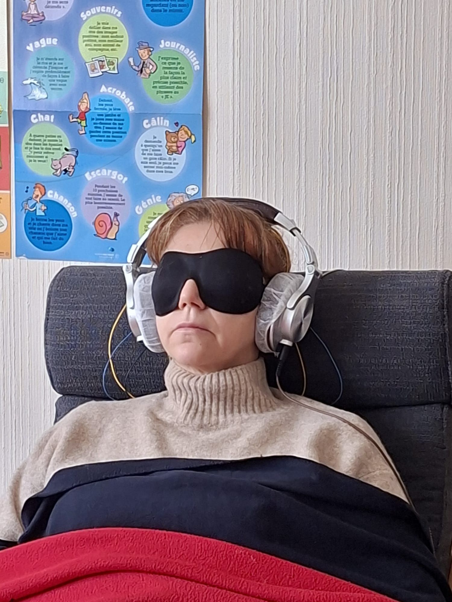 Personne assise portant un casque et un masque noir sur les yeux