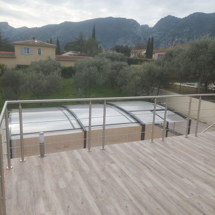 Terrasse de piscine avec piscine couverte et vue sur les montagnes.