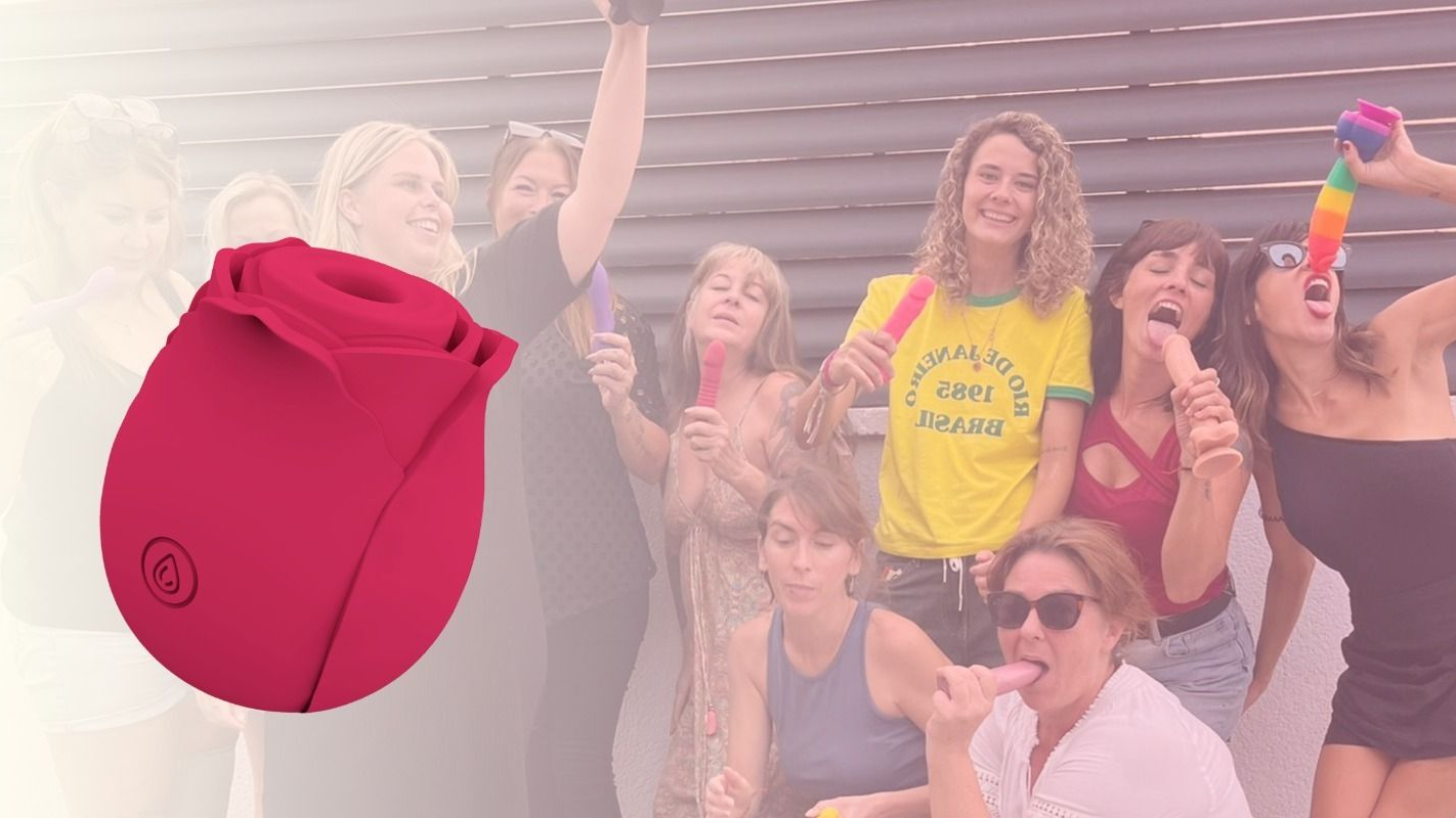 Juguete sexual rojo en primer plano, grupo de mujeres posando, algunas con objetos fálicos coloridos.