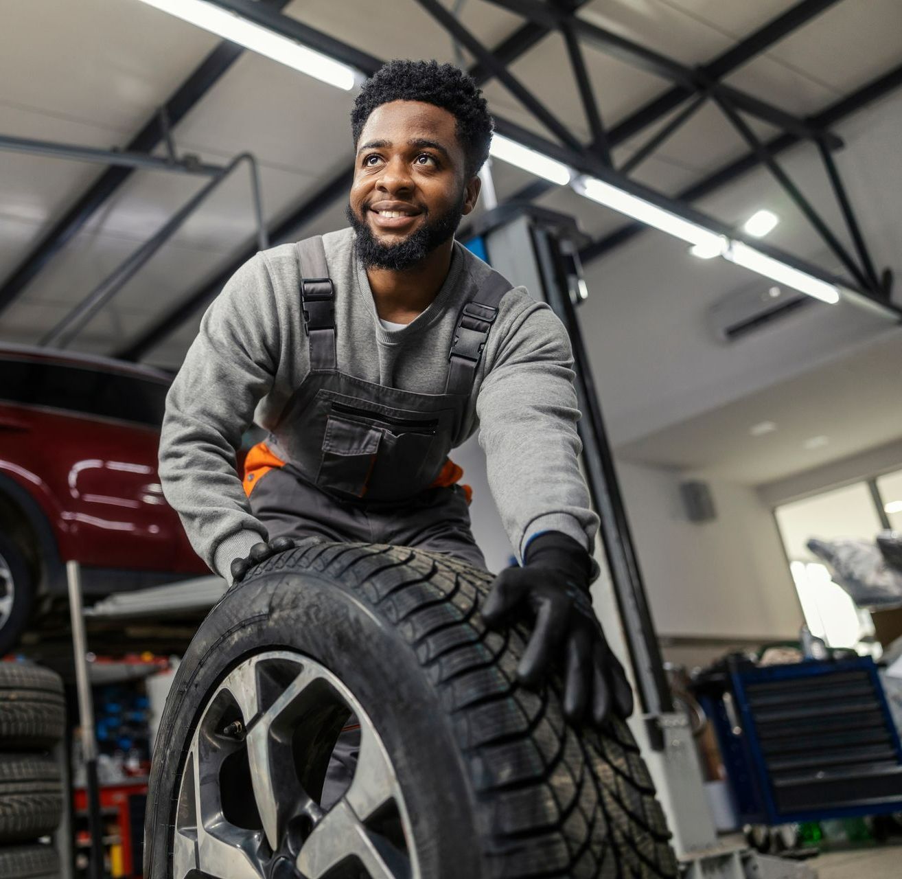 Technicien qui déplace un pneu