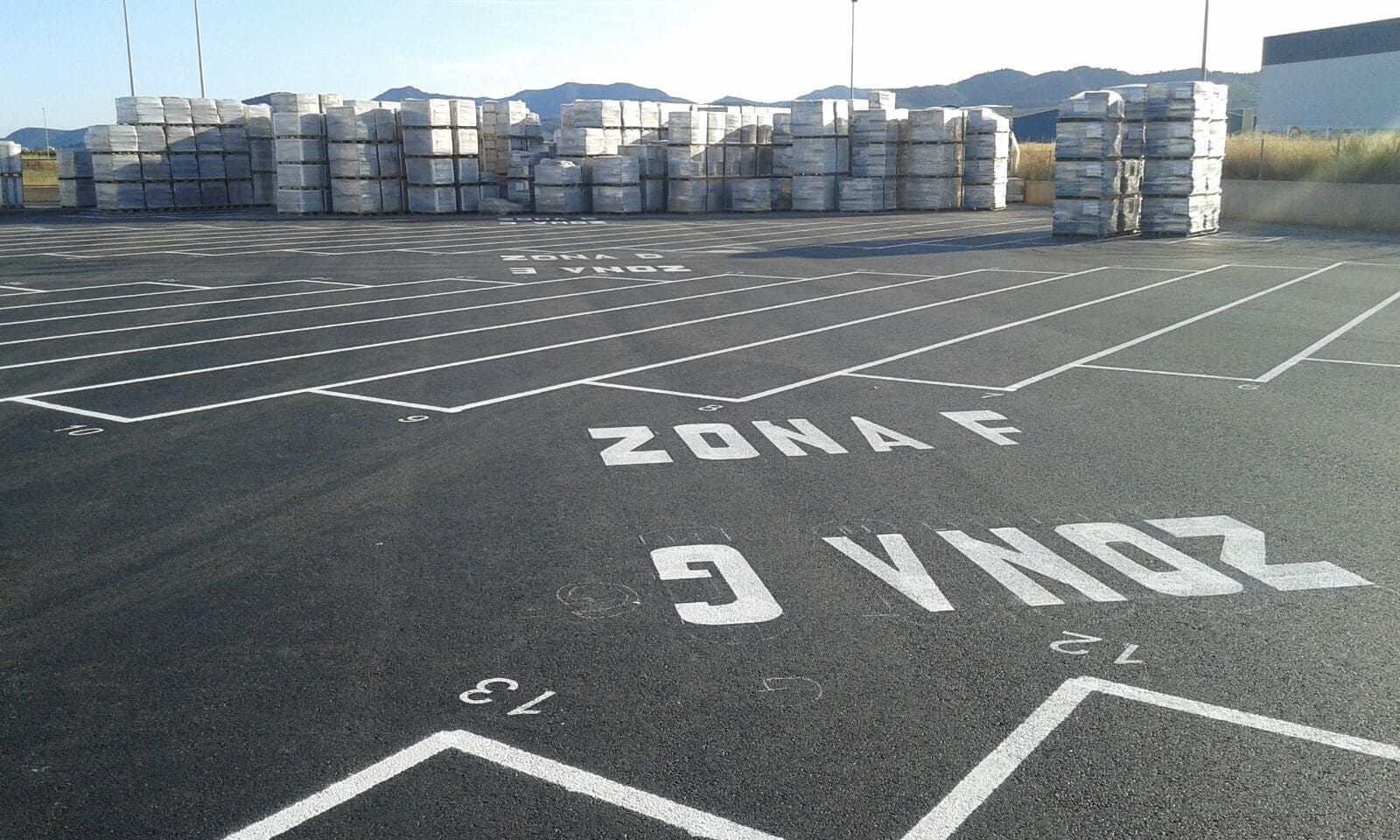 Asfalto negro con marcas blancas y bloques apilados. Se lee 