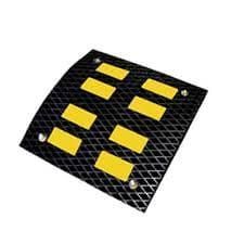 Reductor de velocidad de caucho negro con bandas reflectantes amarillas.