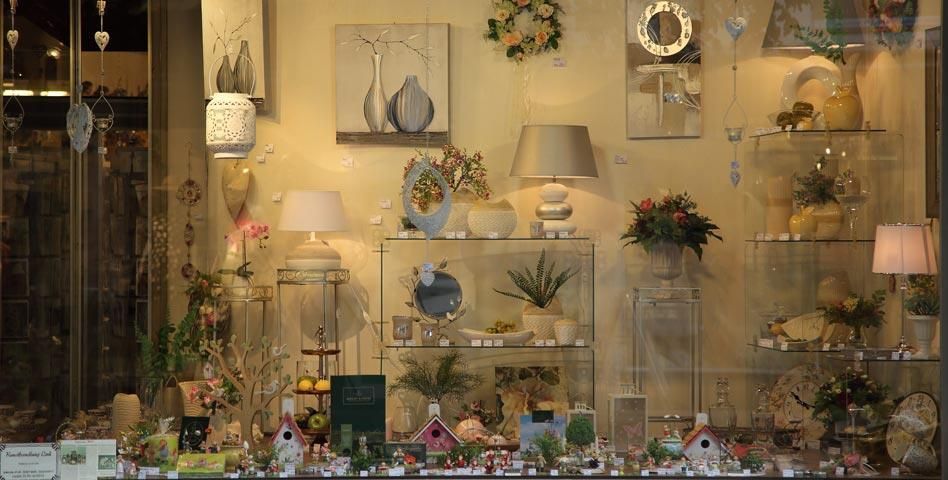 Ein Schaufenster mit Lampen und Vasen auf Regalen