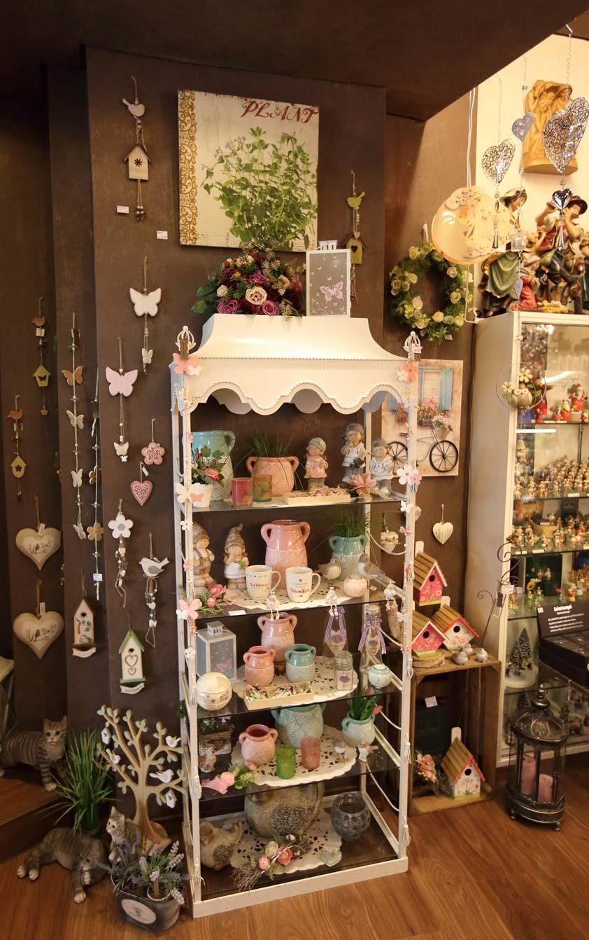 Ein Raum mit einem Regal voller Dekorationen und einem Bild von einem Baum an der Wand