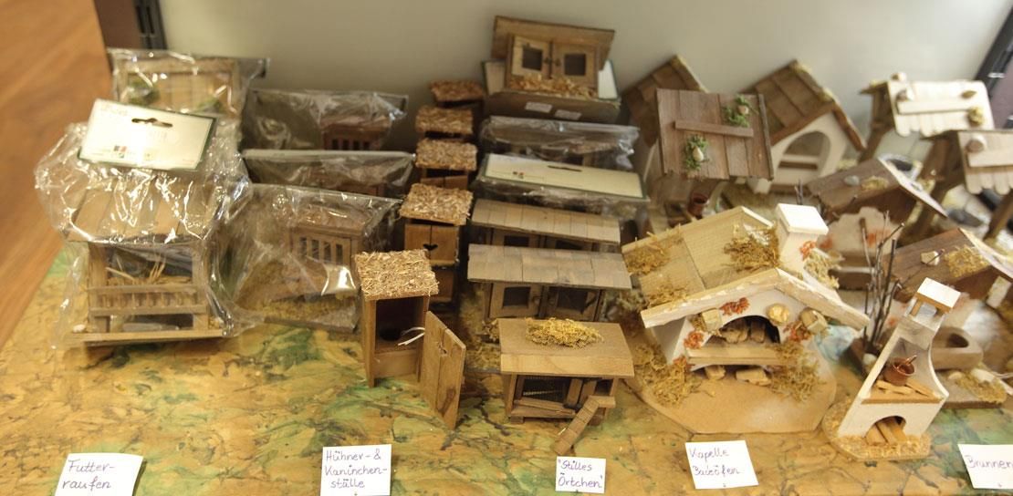 Eine Reihe kleiner Holzhäuser stehen aufgereiht auf einem Tisch