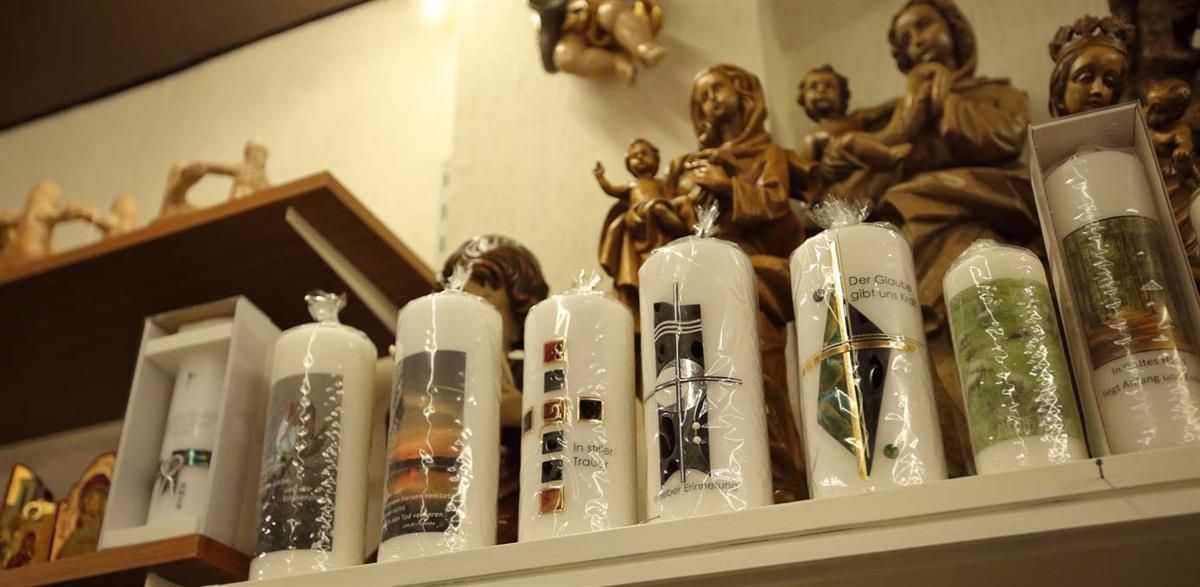 Ein Regal mit Kerzen und Statuen darauf