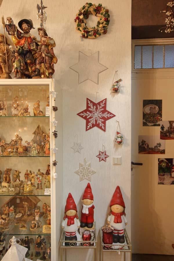 Eine Vitrine mit Weihnachtsdekorationen, darunter Zwerge und ein Kranz