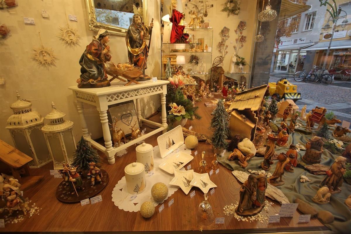 Eine Ausstellung von Kerzen und Figuren in einem Schaufenster