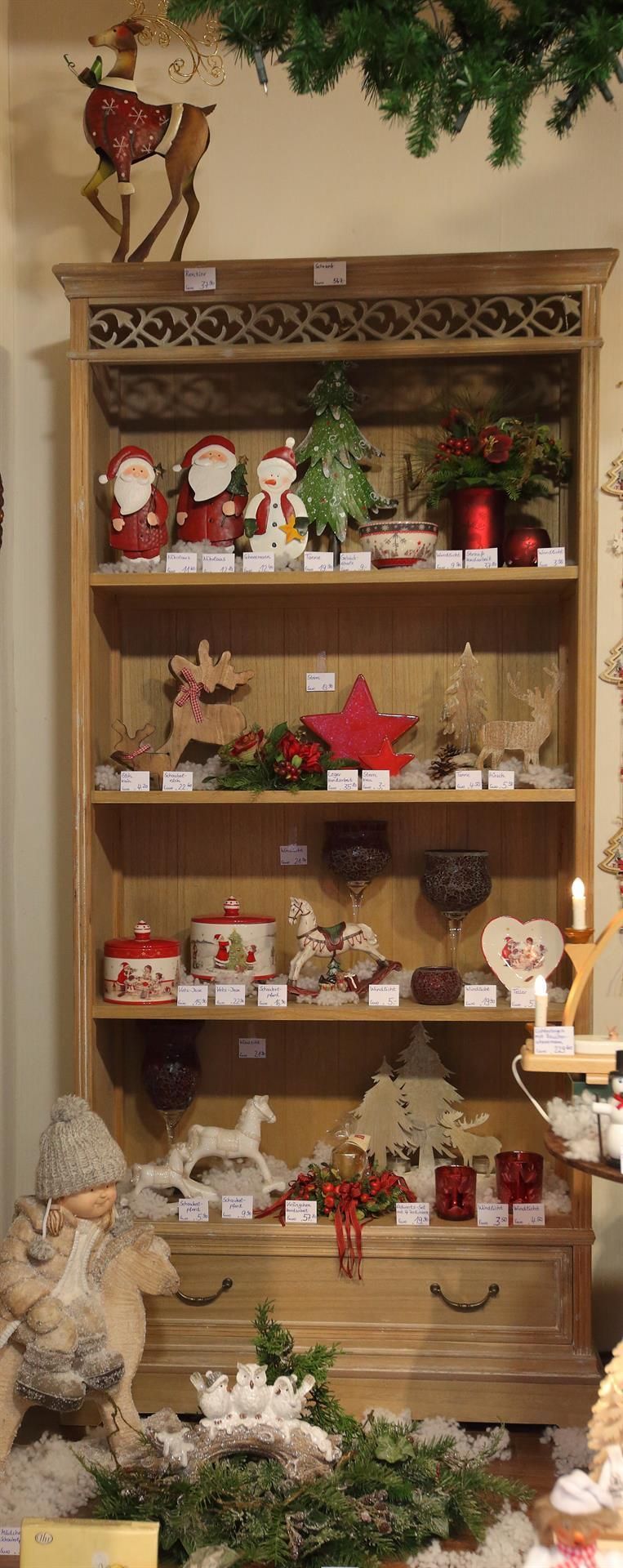 Ein Holzregal mit Weihnachtsdekorationen darauf