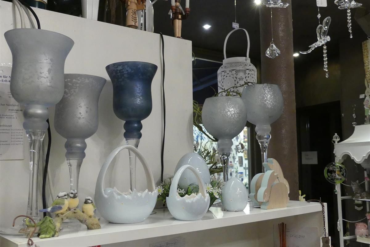 Ein Regal mit verschiedenen Vasen und Laternen darauf