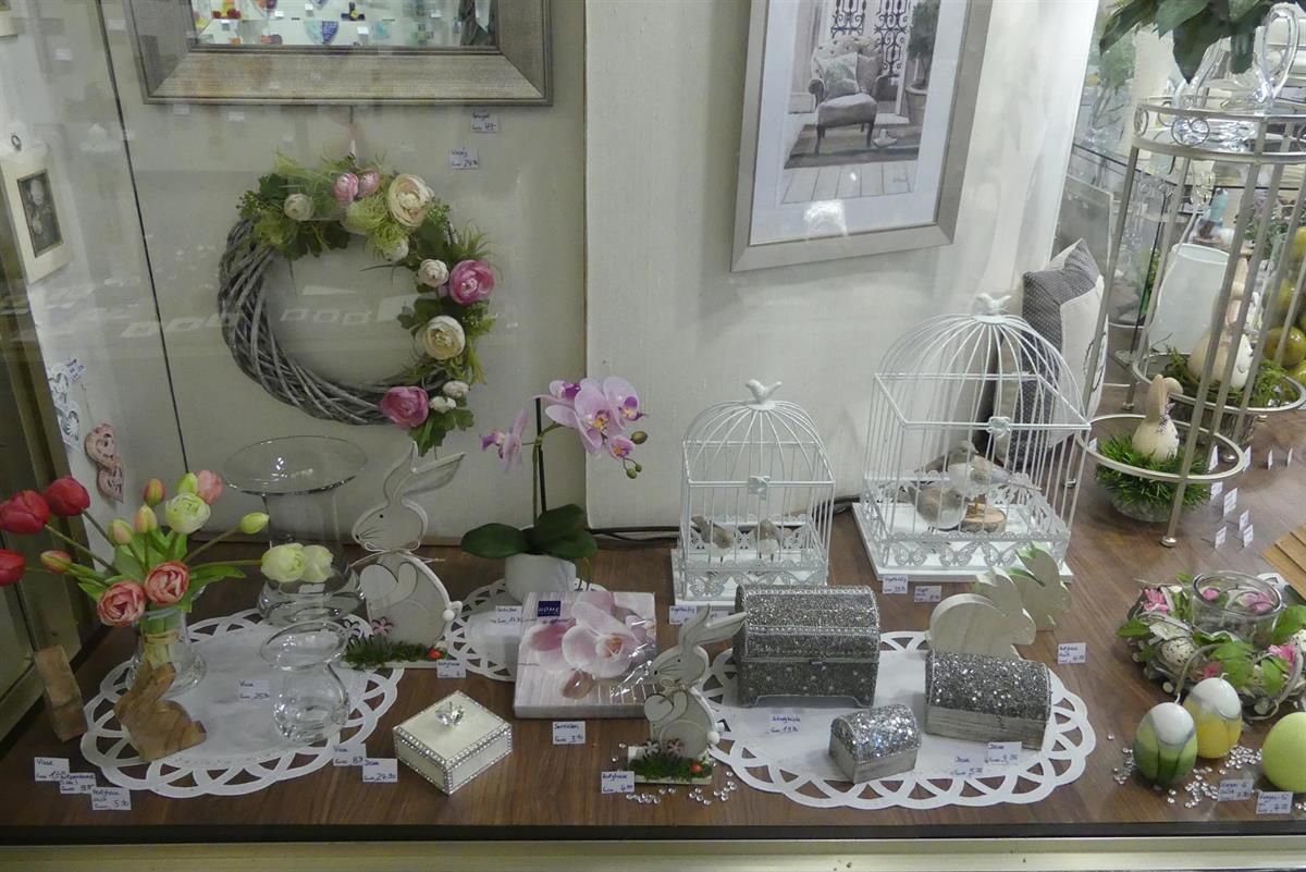 Eine Ausstellung von Blumen und Dekorationen in einem Schaufenster