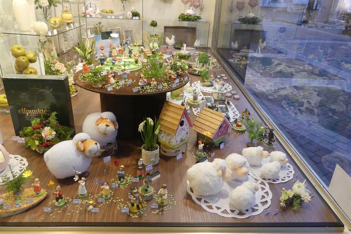 Eine Ausstellung von Schafen und Figuren in einem Schaufenster