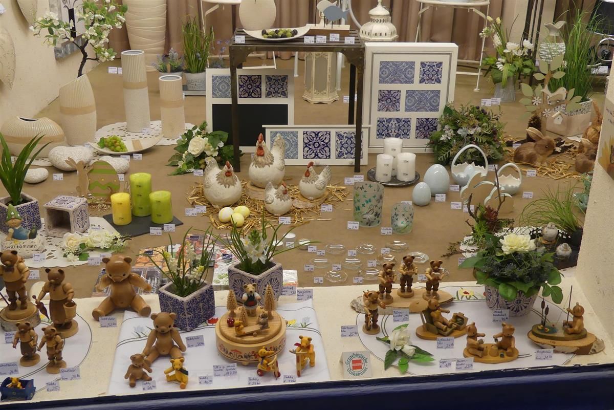 Eine Ausstellung von Figuren, Blumen und Kerzen mit einem Tisch im Hintergrund