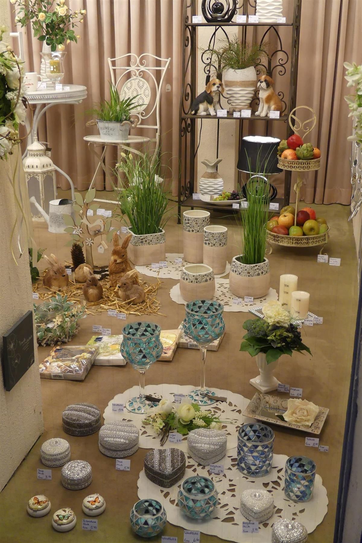 Eine Ausstellung von Blumen und Kerzen in einem Schaufenster