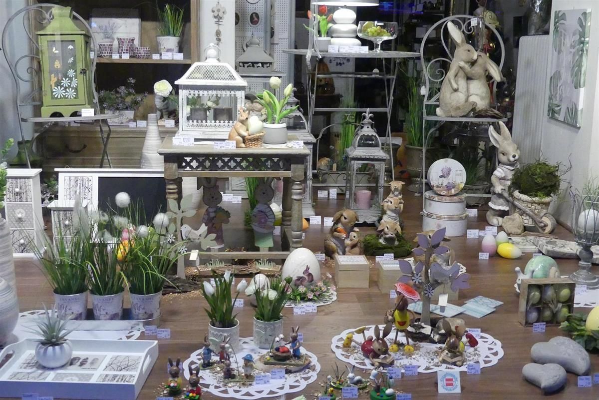 Eine Ausstellung von Blumen und Figuren in einem Schaufenster