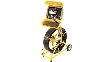 Una cámara de drenaje amarilla está colocada encima de un carrito amarillo.