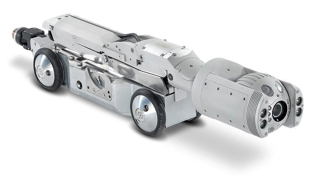 Un automóvil plateado con una cámara acoplada se encuentra sobre una superficie blanca.