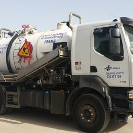 Un camión blanco está estacionado al costado de la carretera.