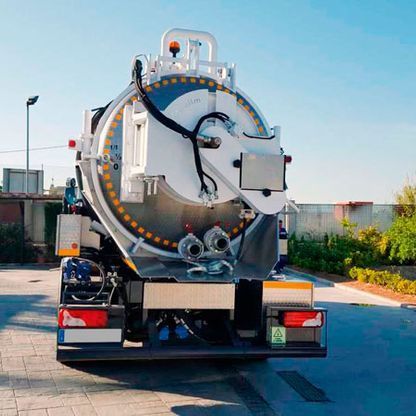 Un gran camión de vacío está estacionado en un estacionamiento.