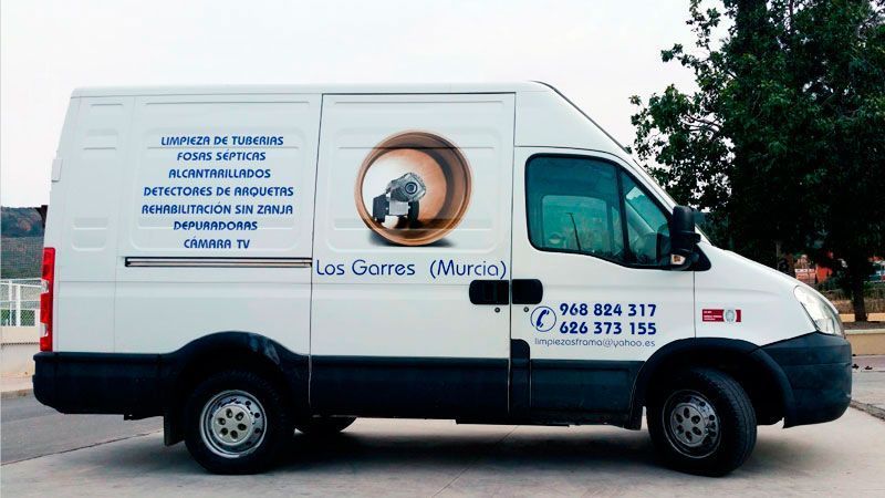 Una camioneta blanca está estacionada al costado de la carretera