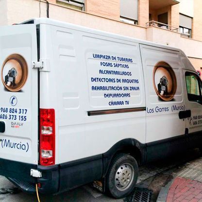 Una camioneta blanca está estacionada al costado de la carretera